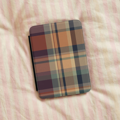 Autumn Plaid Kindle case lying on striped bedding