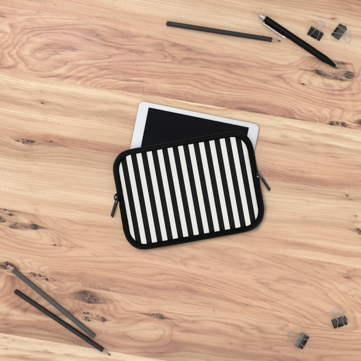 Black Cabana Stripe laptop sleeve on a wooden desk with a tablet sliding in