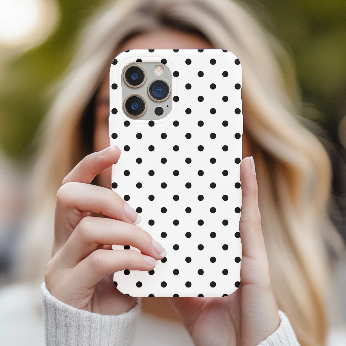 Black Polka Dot tough phone case held up in front of the face