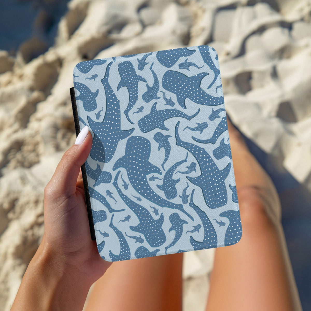 Hand holding a blue whale shark Kindle case outdoors