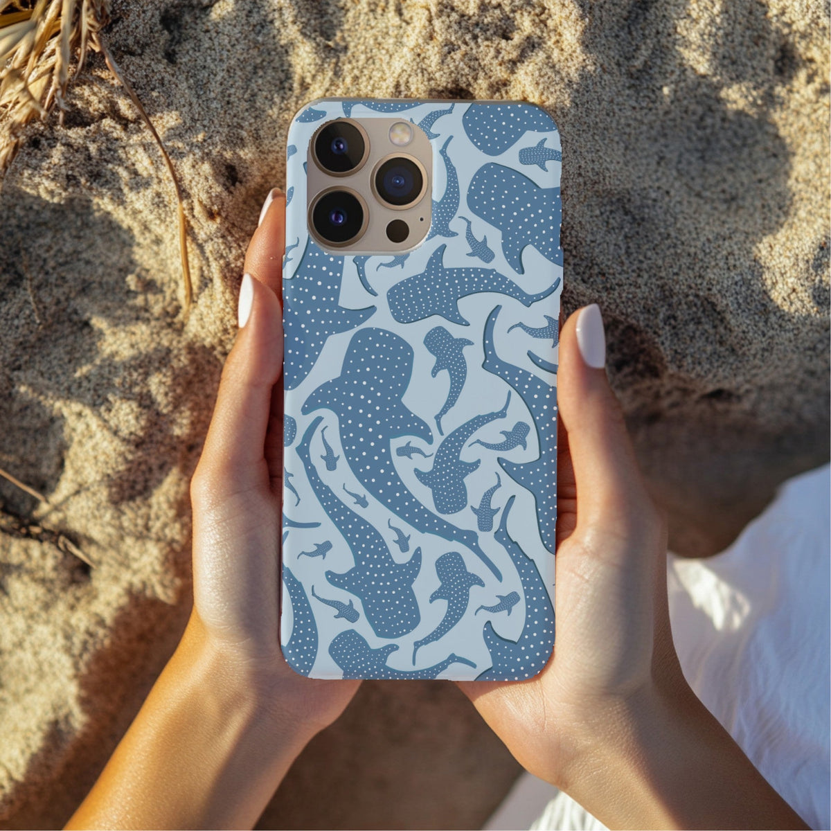 Hands holding a Blue Whale Shark tough phone case over sand