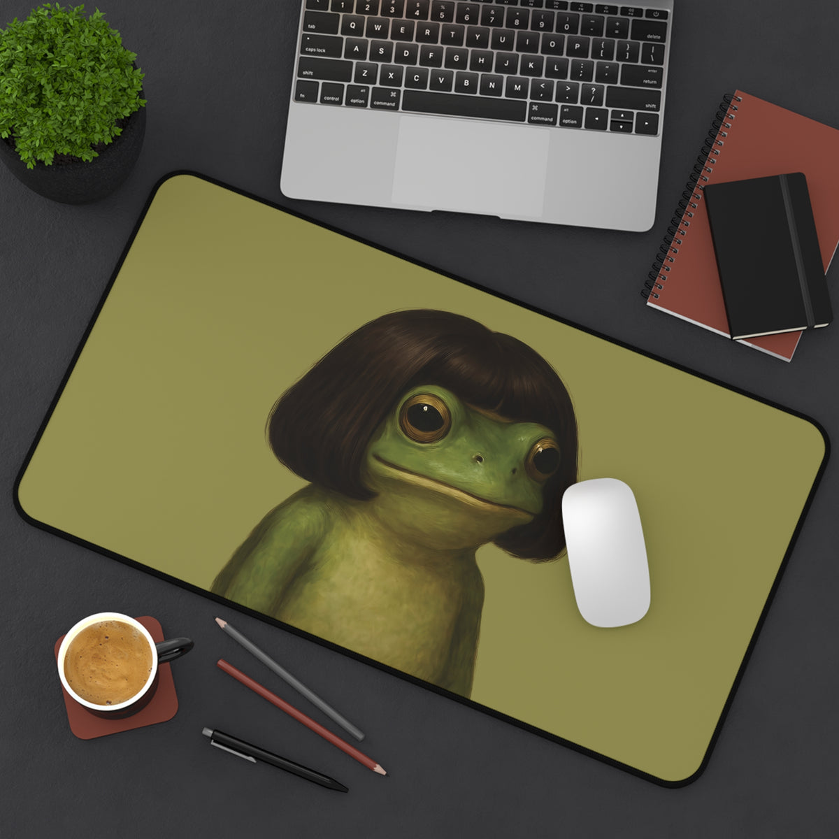 Bob Cut Frog desk mat on a dark desk with a laptop and mouse