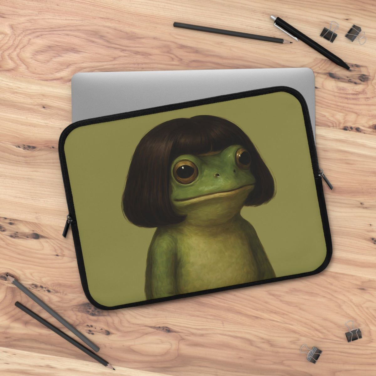 Bob Cut Frog laptop sleeve on a wooden desk with a laptop