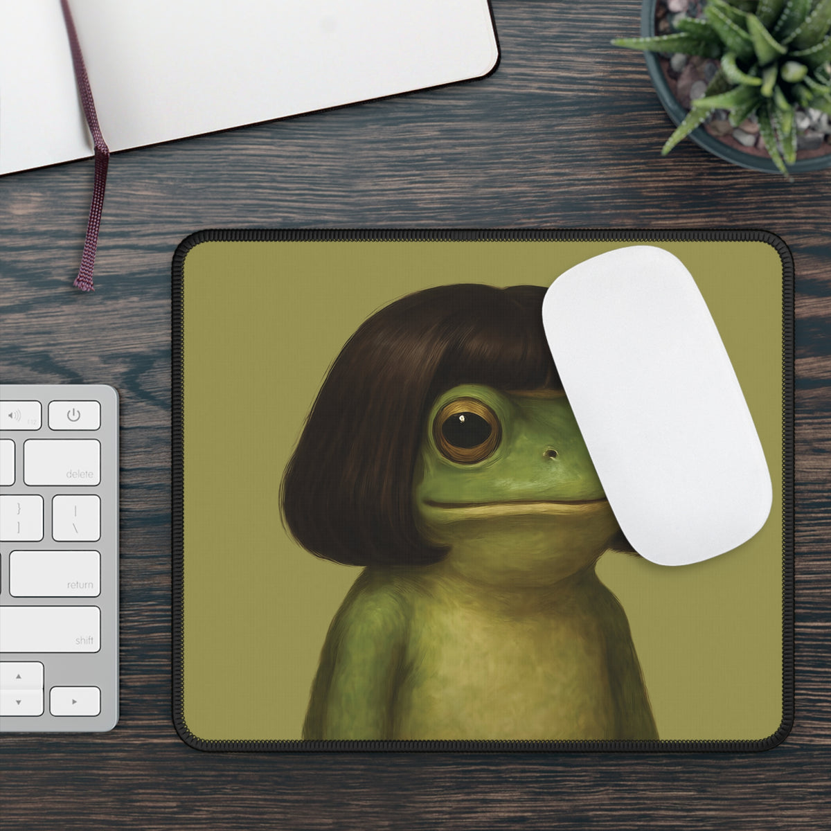 Bob Cut Frog mouse mat on a wooden desk with a keyboard and white mouse