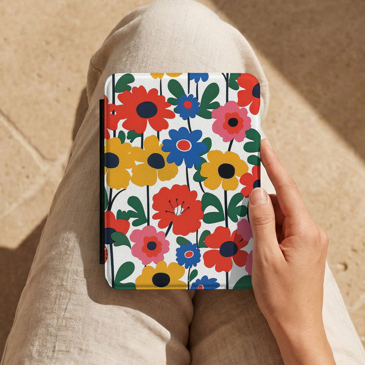 Bold Scandi Floral Kindle case held on a lap in cream trousers