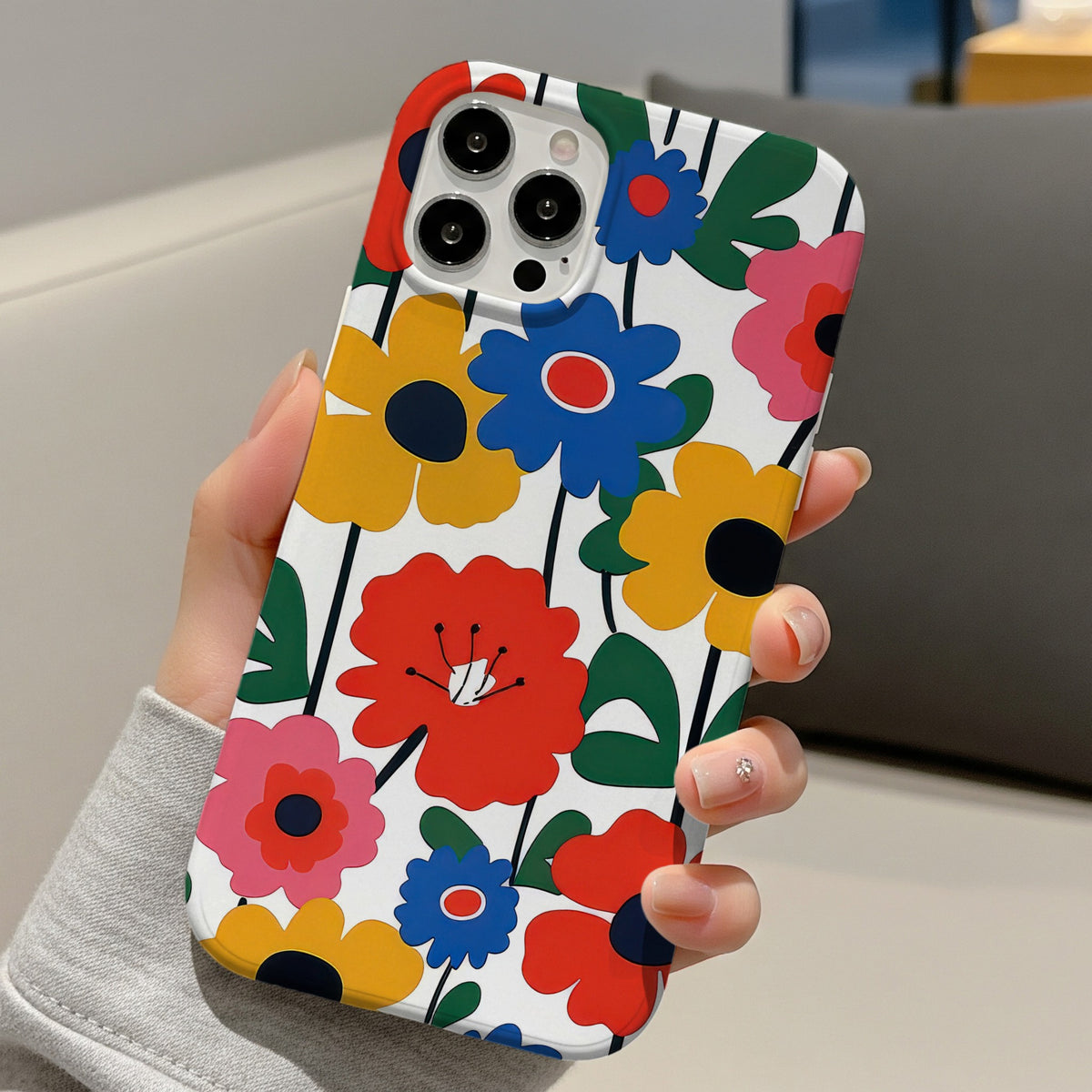 Bold Scandi Floral tough phone case held in one hand on a sofa