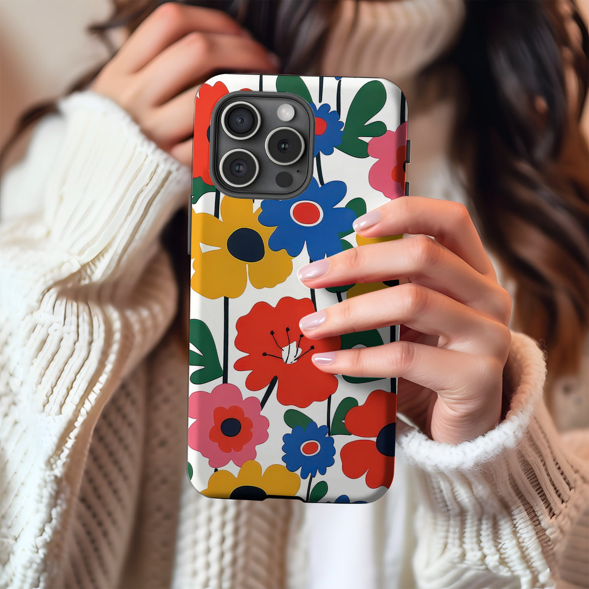 Bold Scandi Floral tough phone case in a mirror selfie with a cream knit sweater