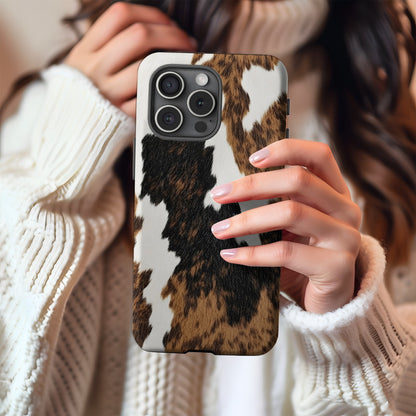 Brown Cow Print tough phone case held up in a mirror selfie with a cream knit sweater
