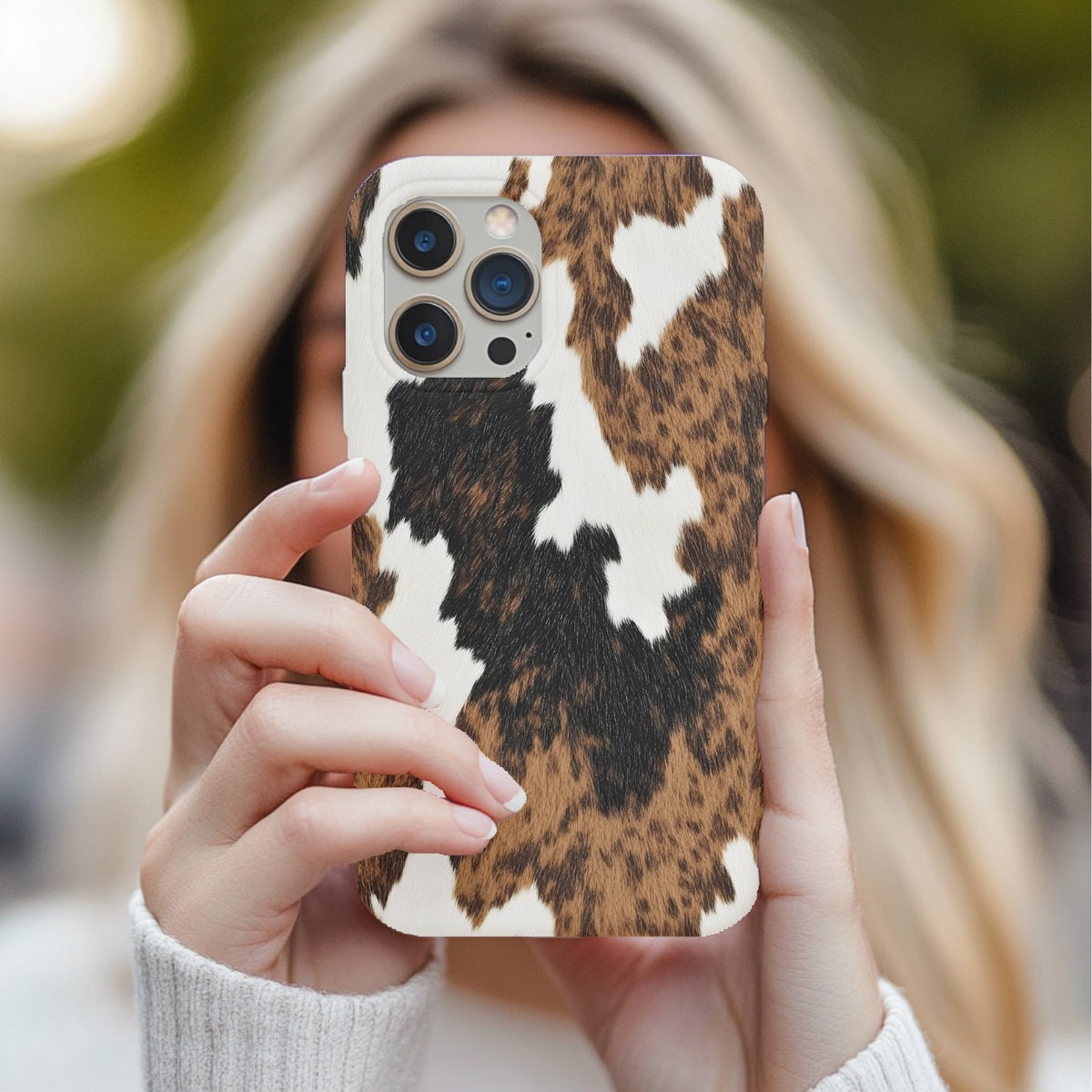 Brown Cow Print tough phone case held in two hands