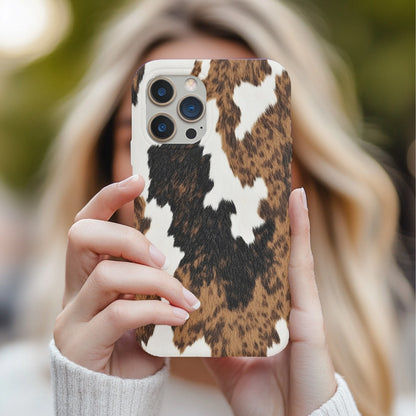 Brown Cow Print tough phone case held in two hands