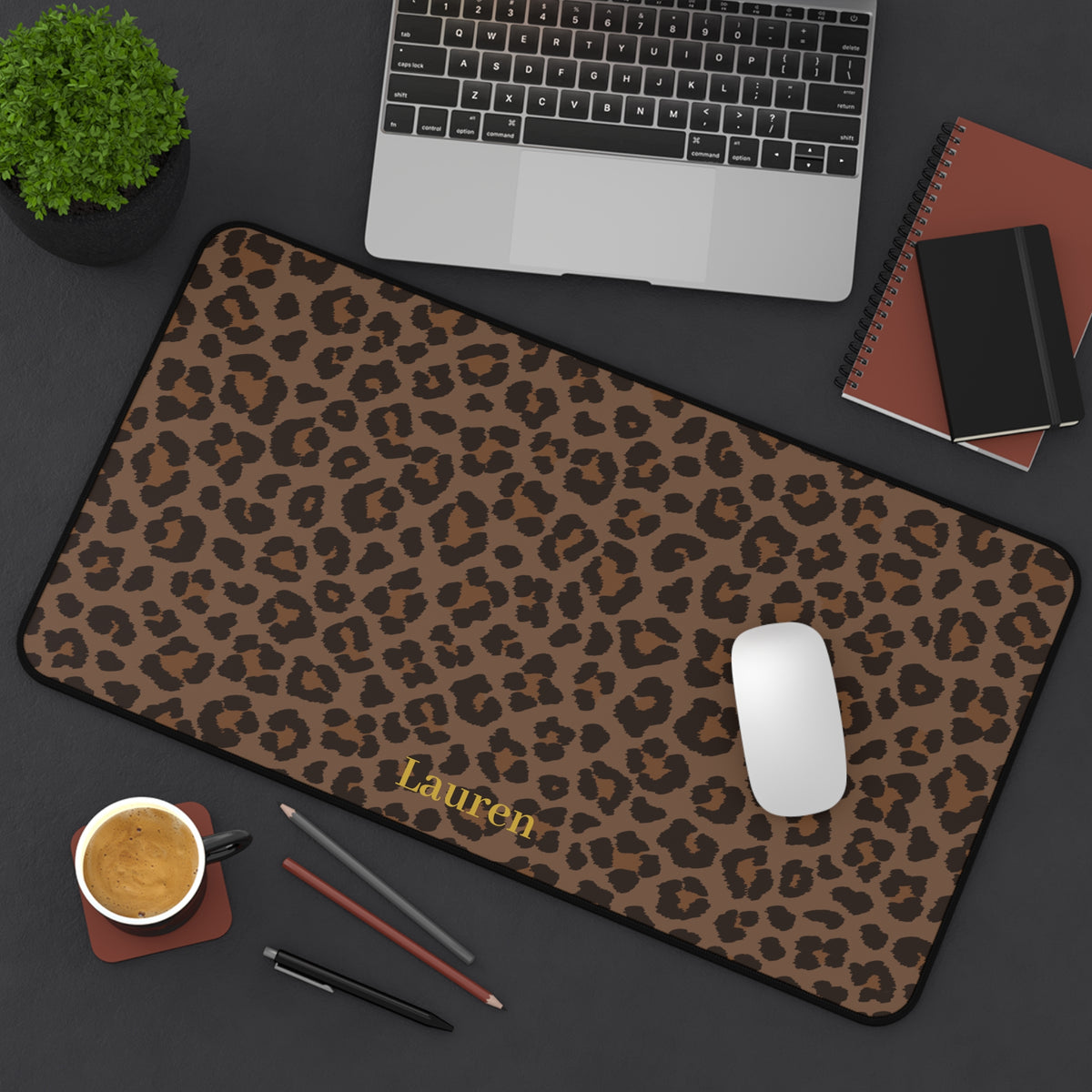 Brown leopard print desk mat from above with a laptop and notebook