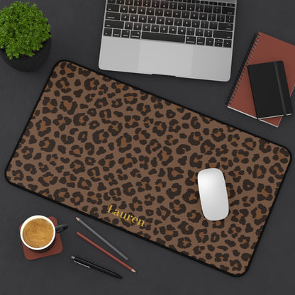 Brown leopard print desk mat from above with a laptop and notebook