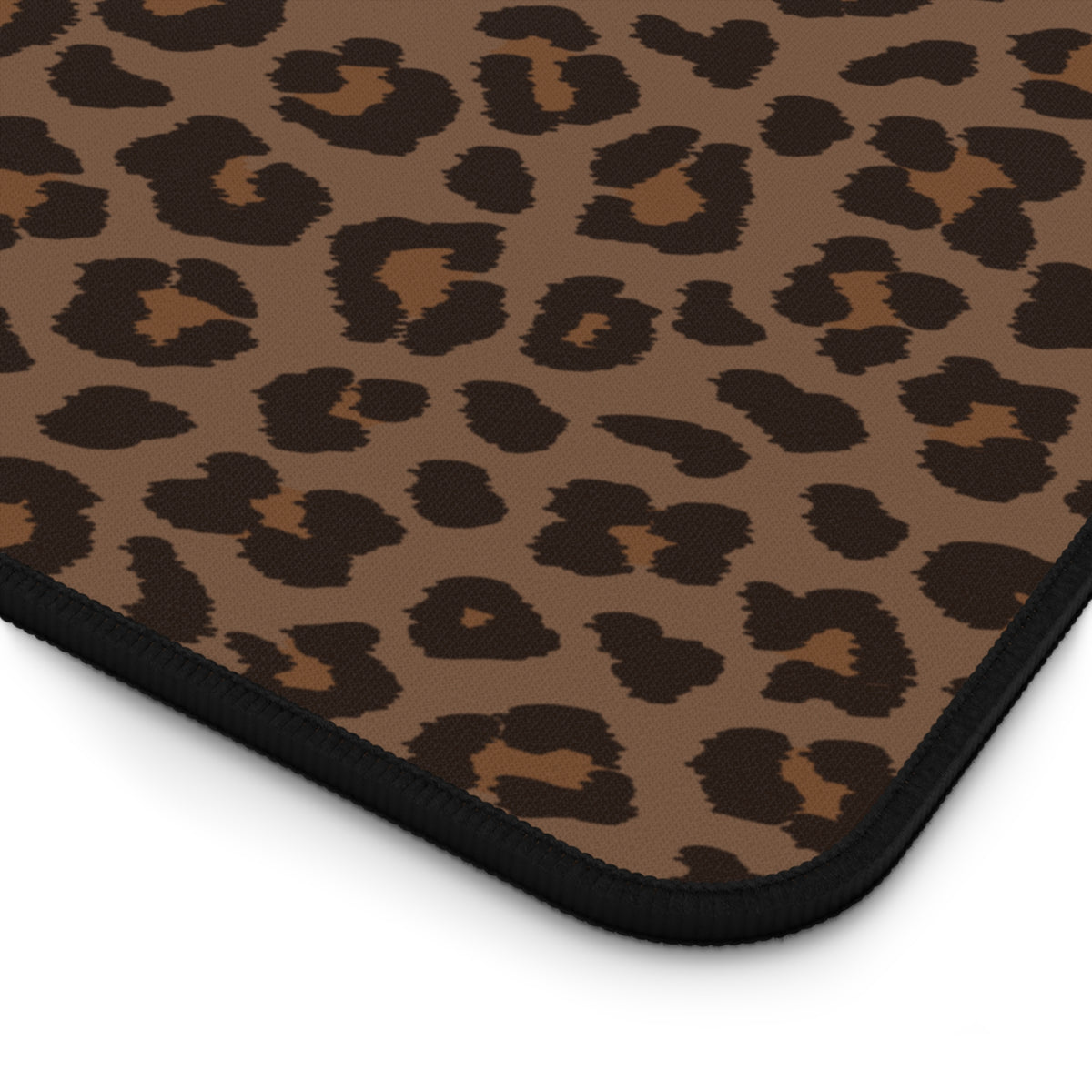 Close-up of the stitched edge of the brown leopard print desk mat