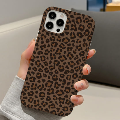 Brown leopard print tough phone case held in hand on a sofa