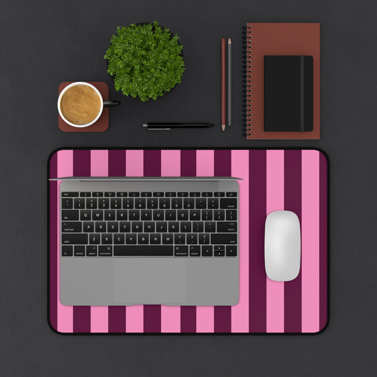 Burgundy Pink Cabana Stripe desk mat on a dark desk with laptop, mouse and coffee
