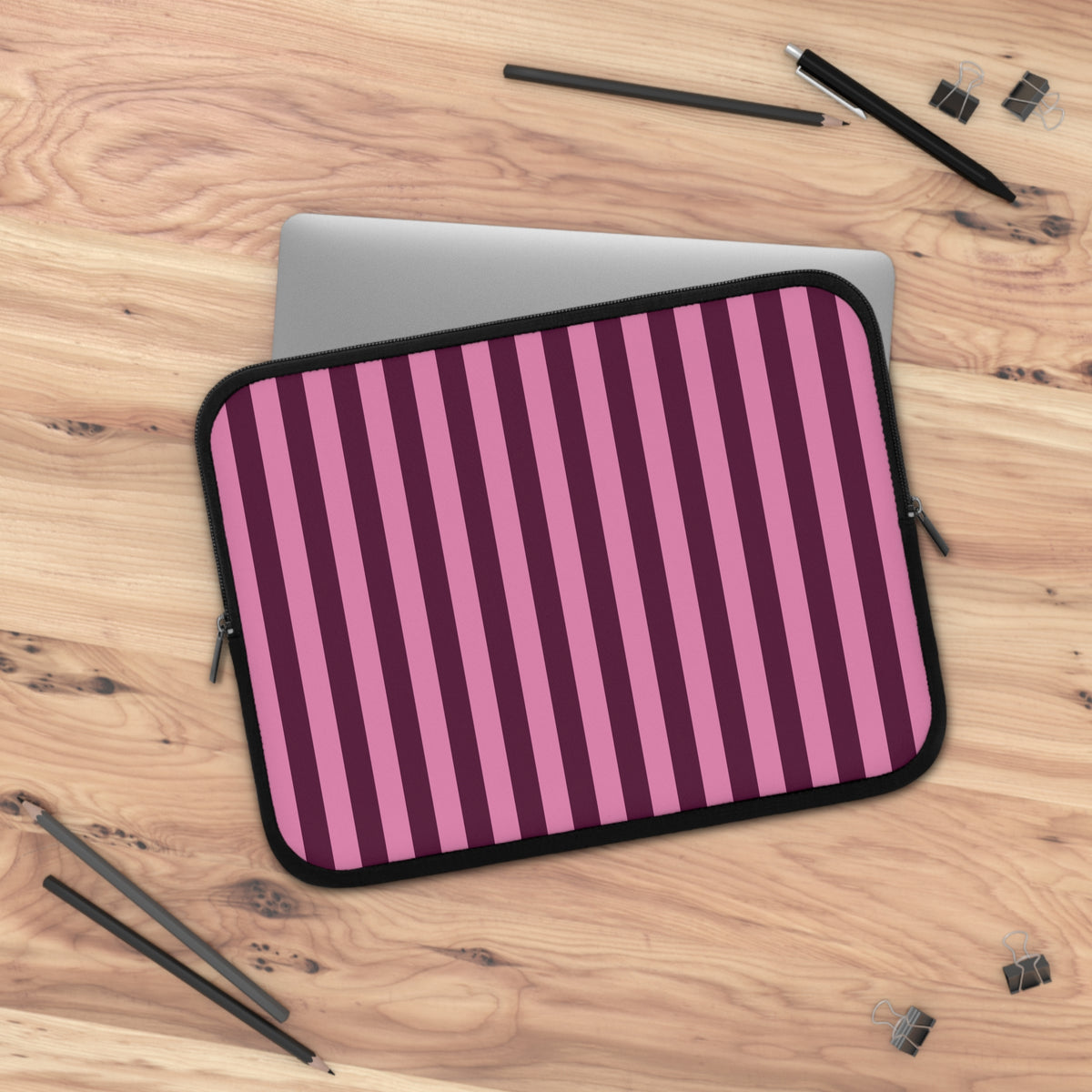 Burgundy Pink Cabana Stripe laptop sleeve on a wooden desk with a laptop