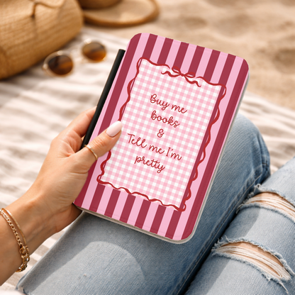 Buy Me Books Kindle case held on a beach blanket while reading