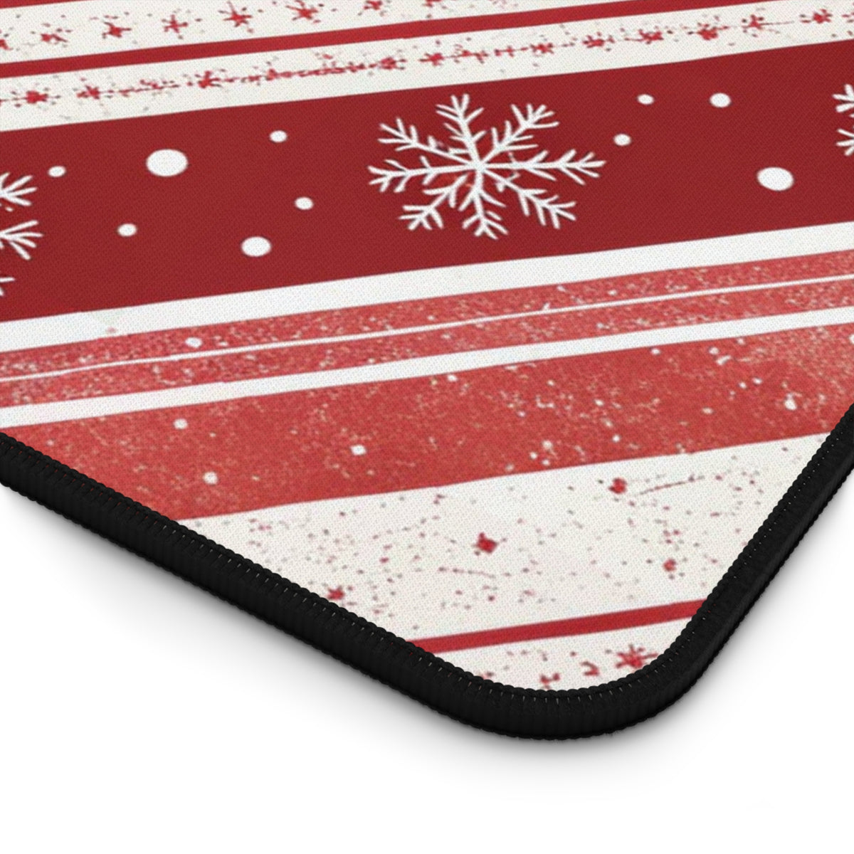 Close-up of the stitched edge on the Candy Cane Snowflake desk mat