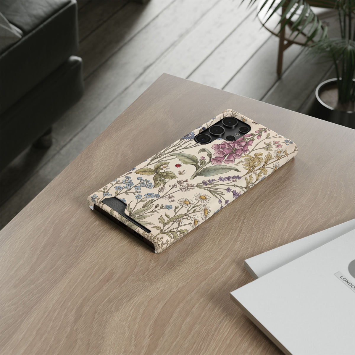 Cottage Meadow card holder phone case lying on a wooden table