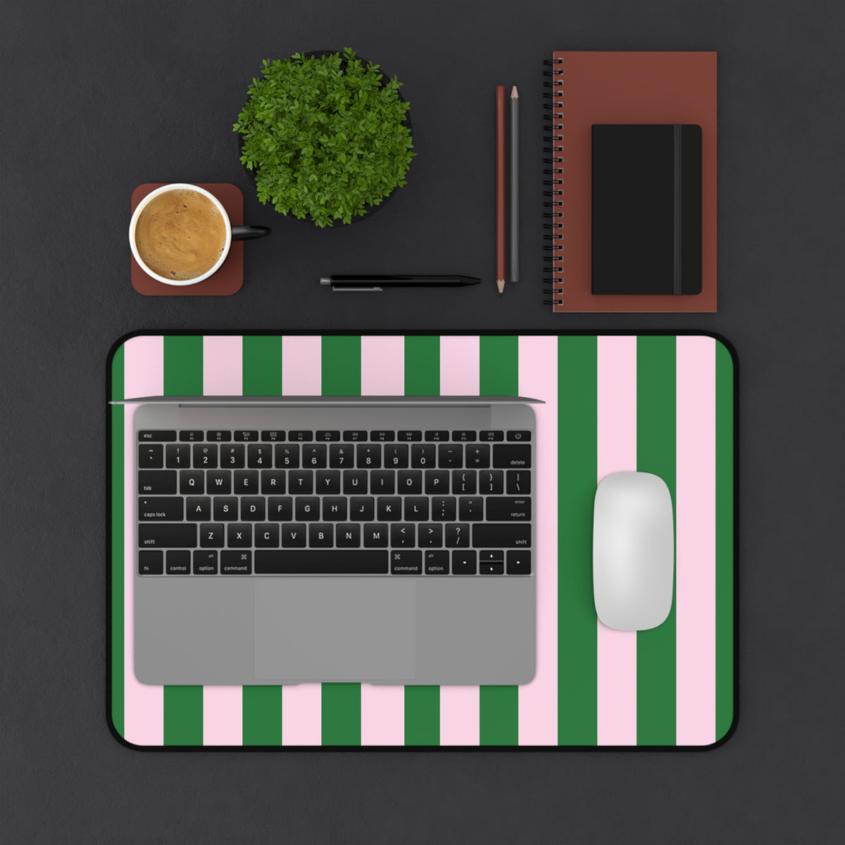 Green cabana stripe desk mat on a dark desk with a laptop and mouse