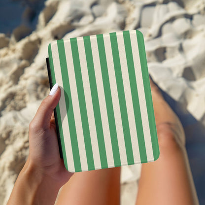 Hand holding a personalised green and cream cabana stripe Kindle case outdoors