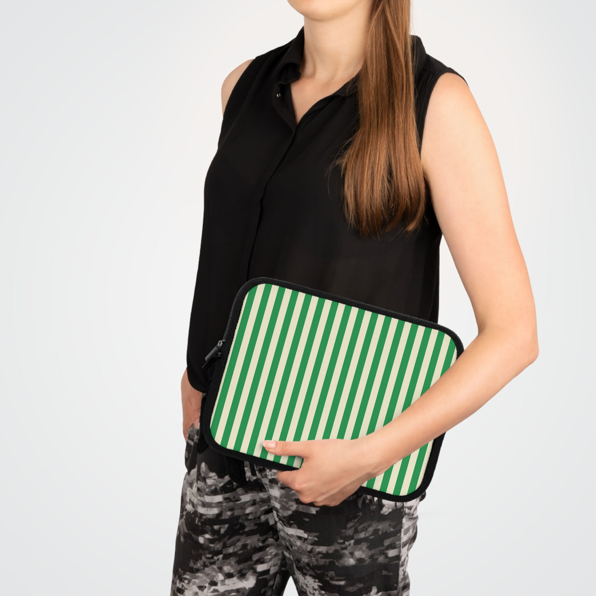 Woman carrying a Green Cream Cabana Stripe laptop sleeve