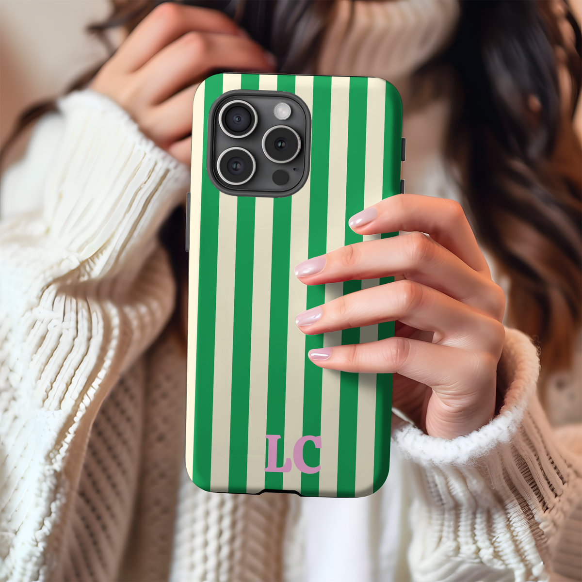 Woman holding a Green Cream Cabana Stripe phone case with custom initials