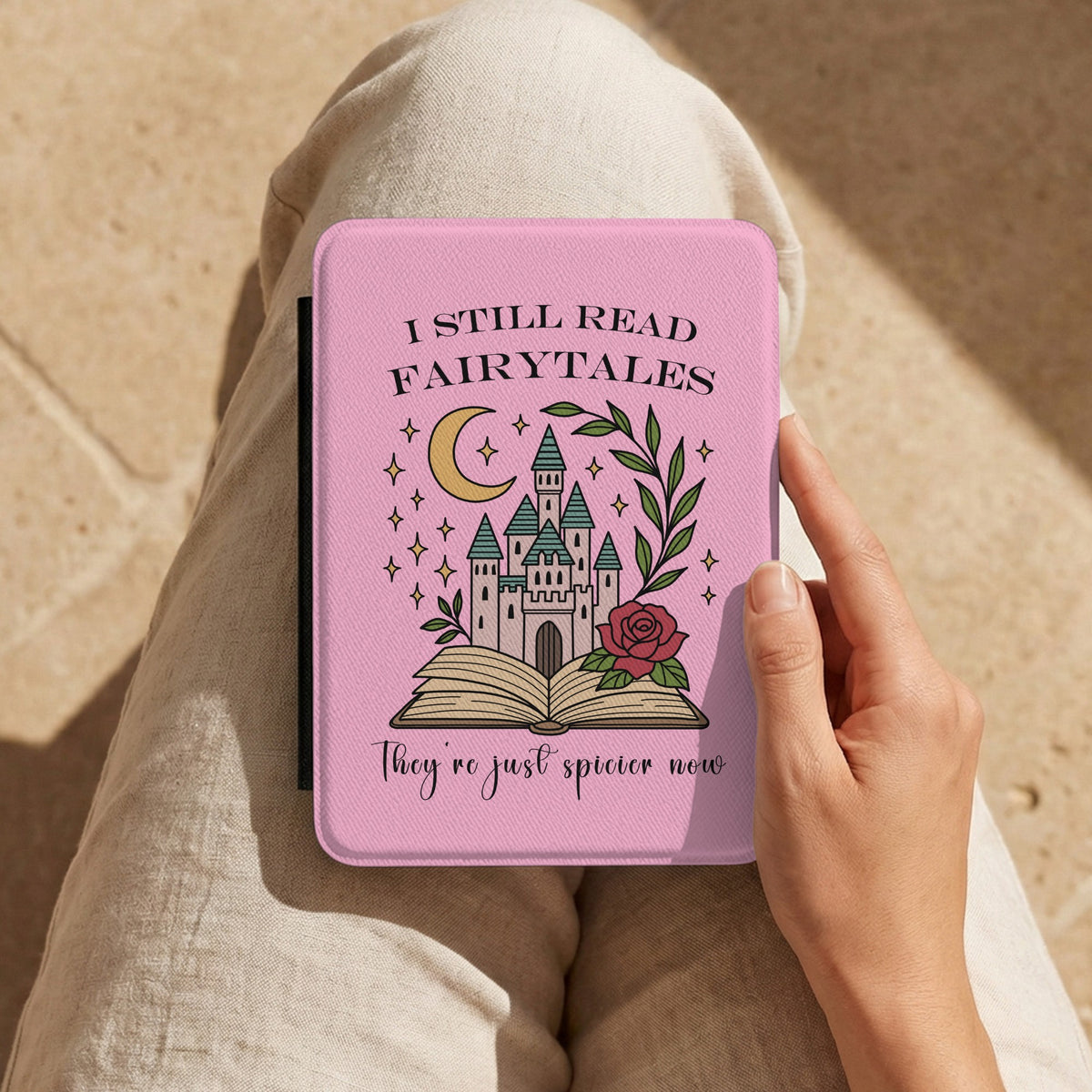 I Still Read Fairytales Kindle case held on the lap while reading