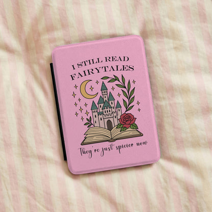 I Still Read Fairytales Kindle case lying on pink striped bedding