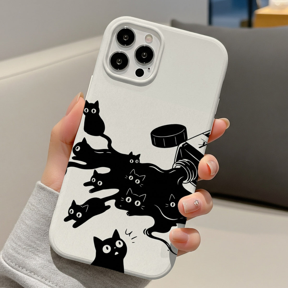 Ink Spill Cats tough phone case held in one hand at a desk