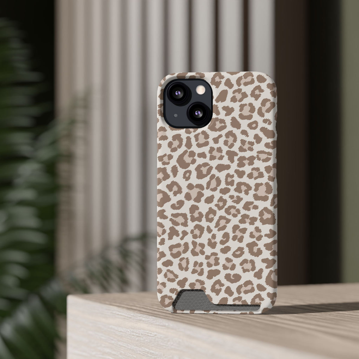 Leopard Print phone case with card holder on a wooden ledge
