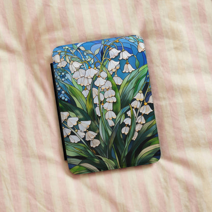 Lily of the Valley Kindle case on a striped bedspread