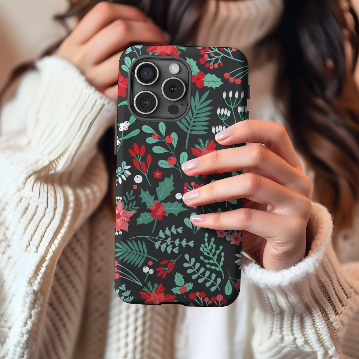 Woman in a cream knit sweater holding the Midnight Poinsettia tough phone case