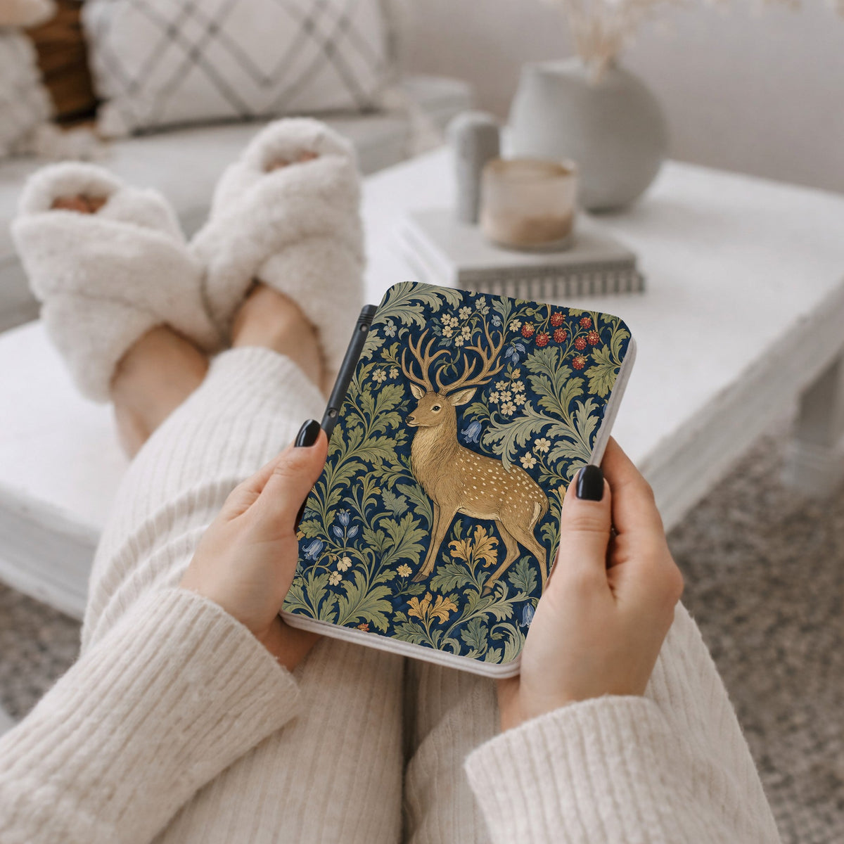 Woman holding the Morris Deer Kindle case on a sofa