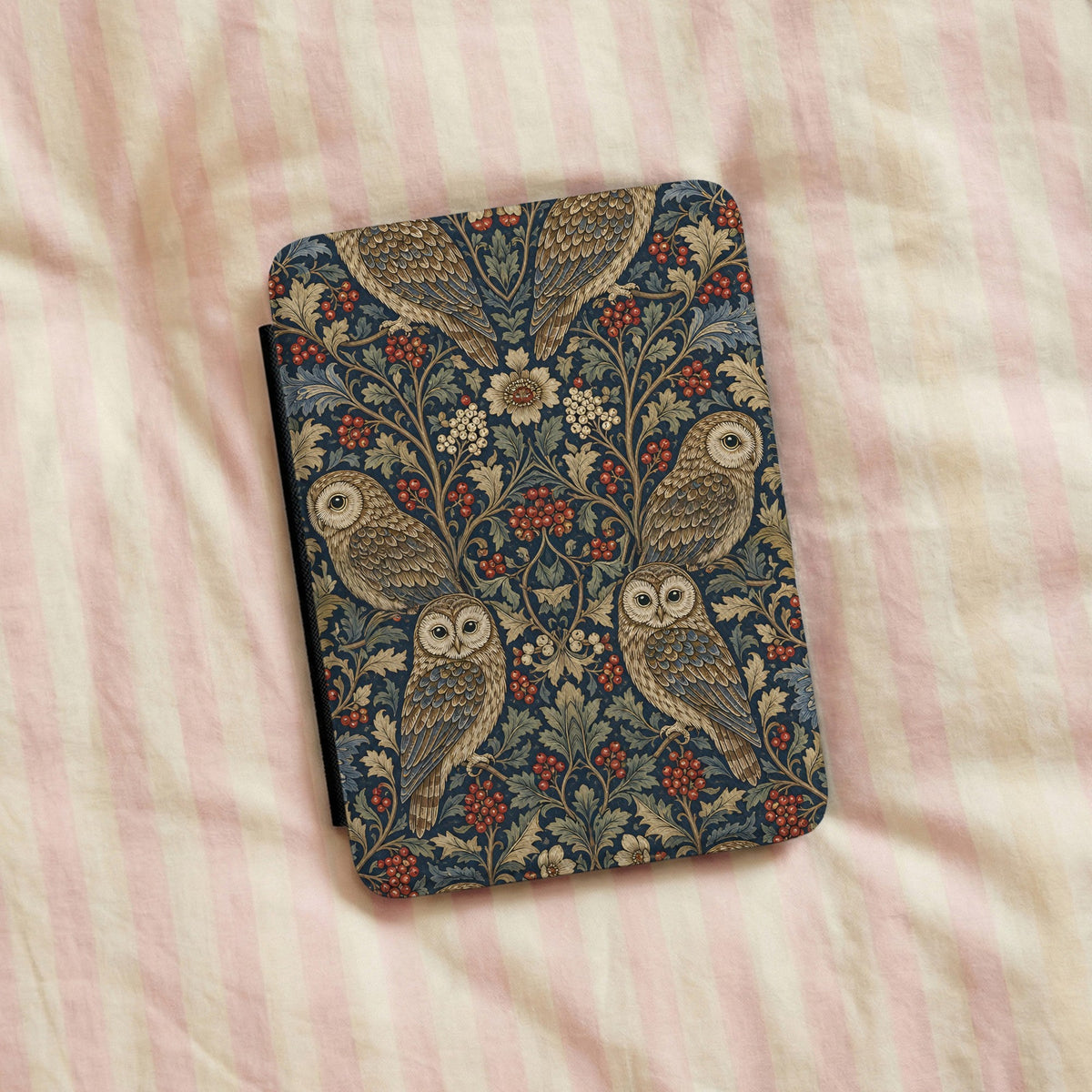 Morris Owls Kindle case on a striped bedspread