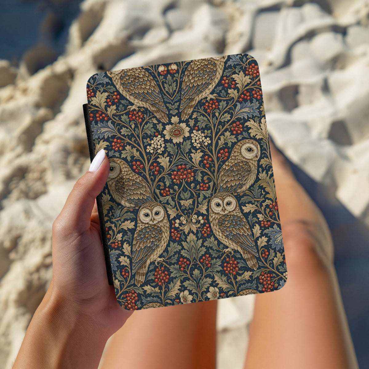 Hands holding the Morris Owls Kindle case outdoors