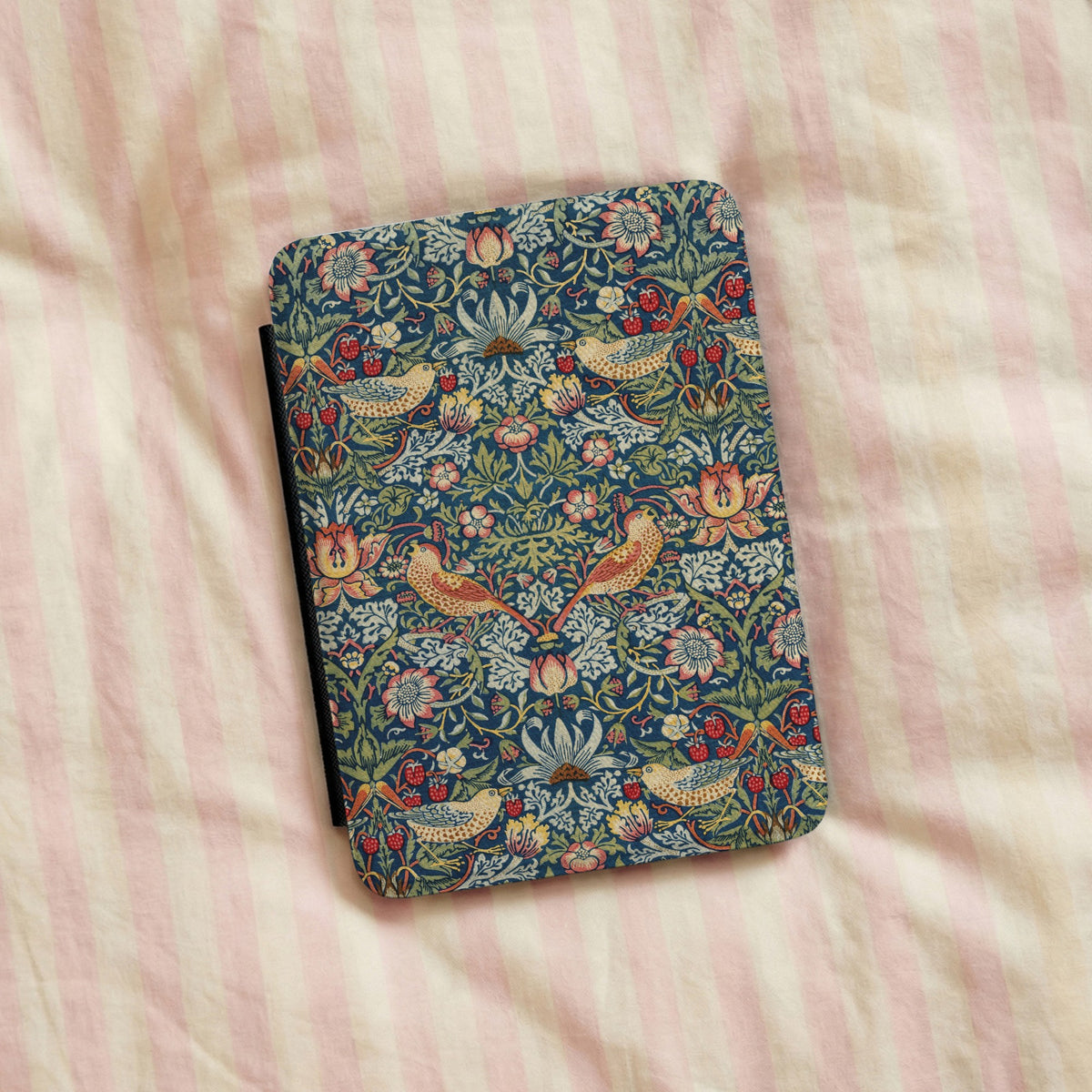 Morris Strawberry Thief Kindle case on pink striped bed linen