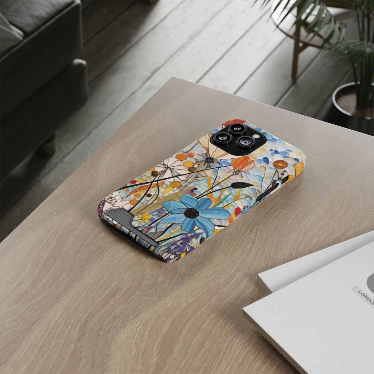 Mosaic Meadow phone case with card holder on a wooden desk
