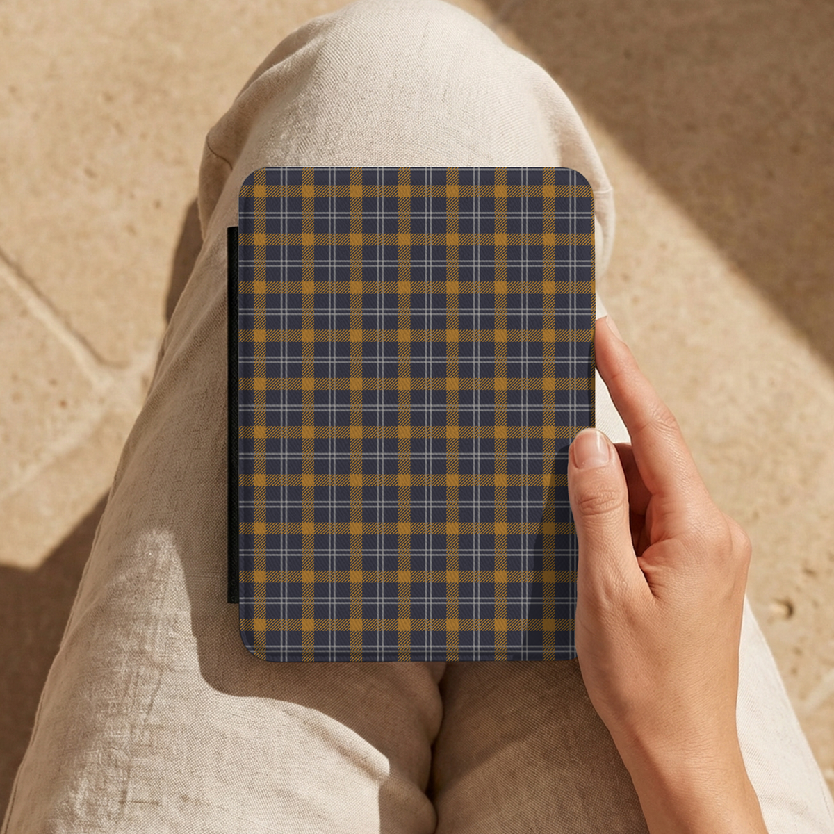 Hand holding a navy ochre plaid Kindle case