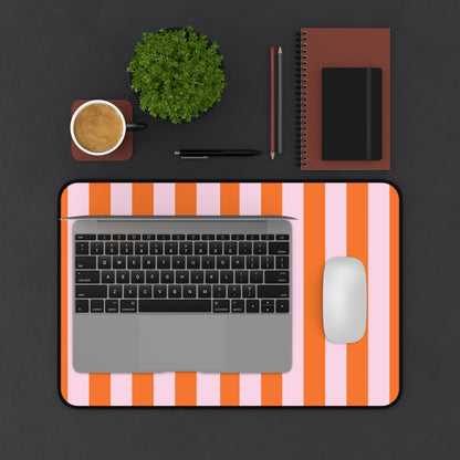 Laptop and mouse on the Orange Cabana Stripe desk mat on a dark desk