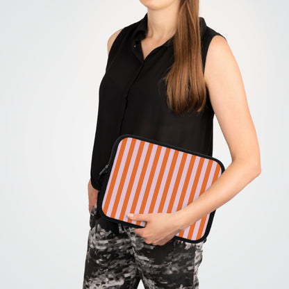 Woman carrying an orange cabana stripe laptop sleeve