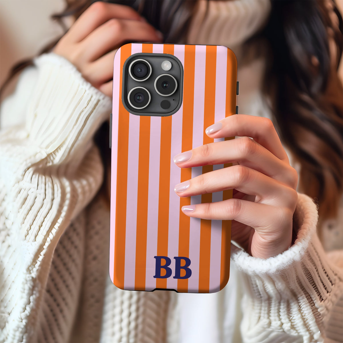 Orange Cabana Stripe tough phone case with BB monogram held in hand