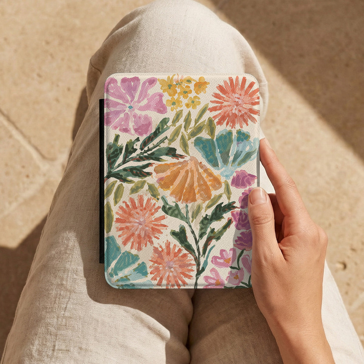 Painted Garden Kindle case held on a lap