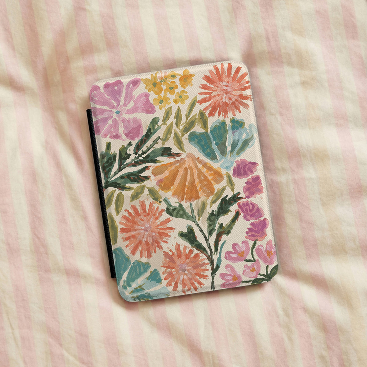 Painted Garden Kindle case lying on pink striped bedding