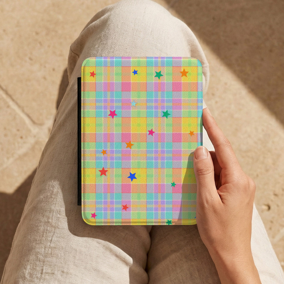 Pastel Plaid Stars Kindle case held on the lap while reading