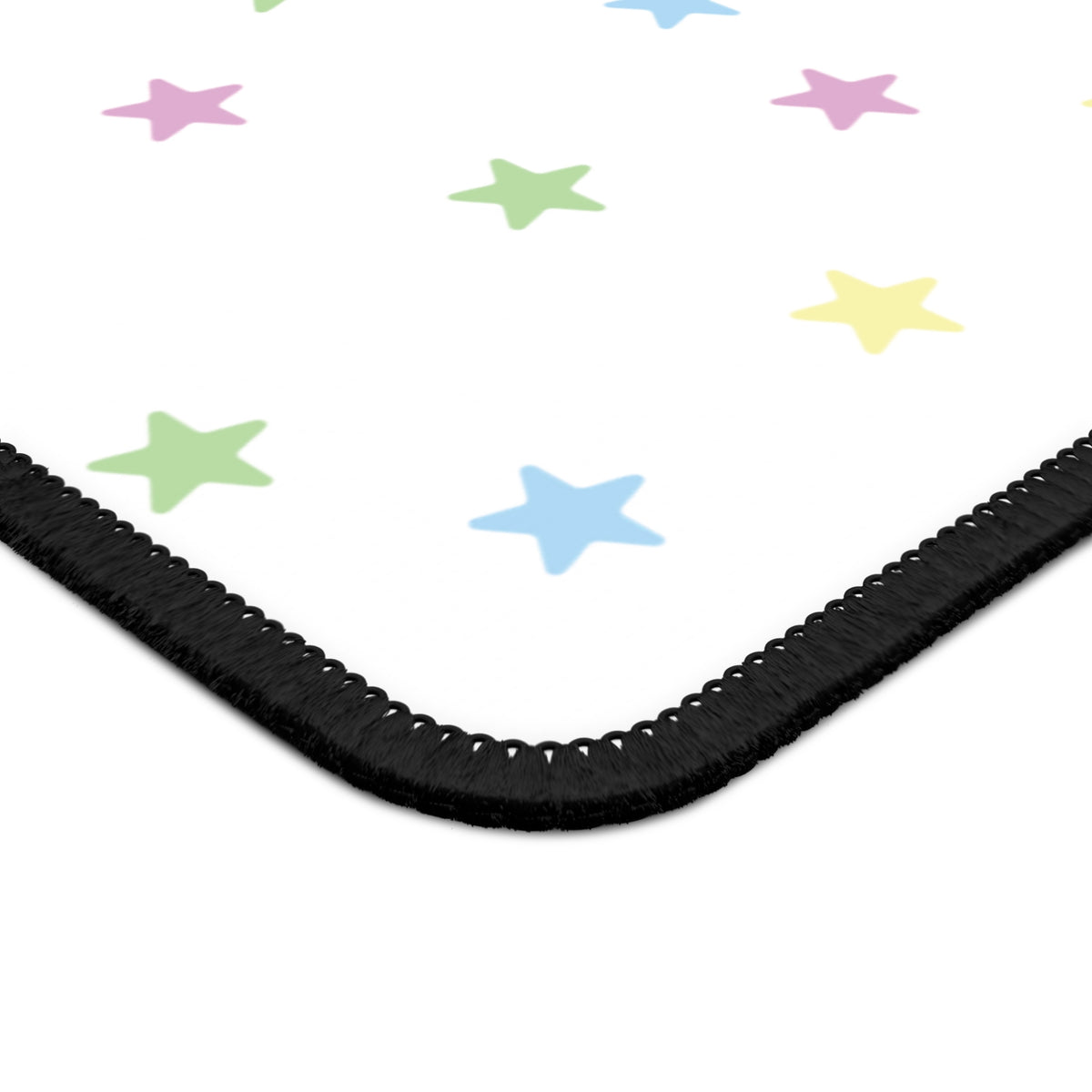 Close-up of the stitched edge and rounded corner of the Pastel Stars mouse mat