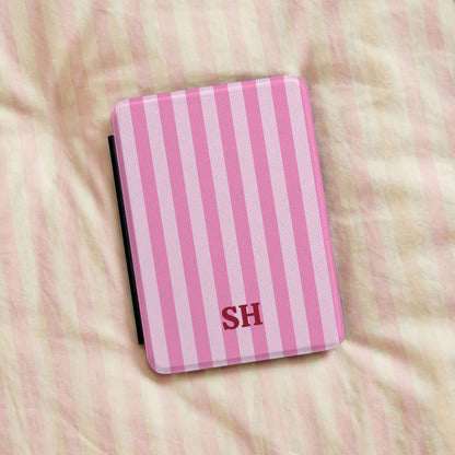 Personalised pink cabana stripe Kindle case on a bed