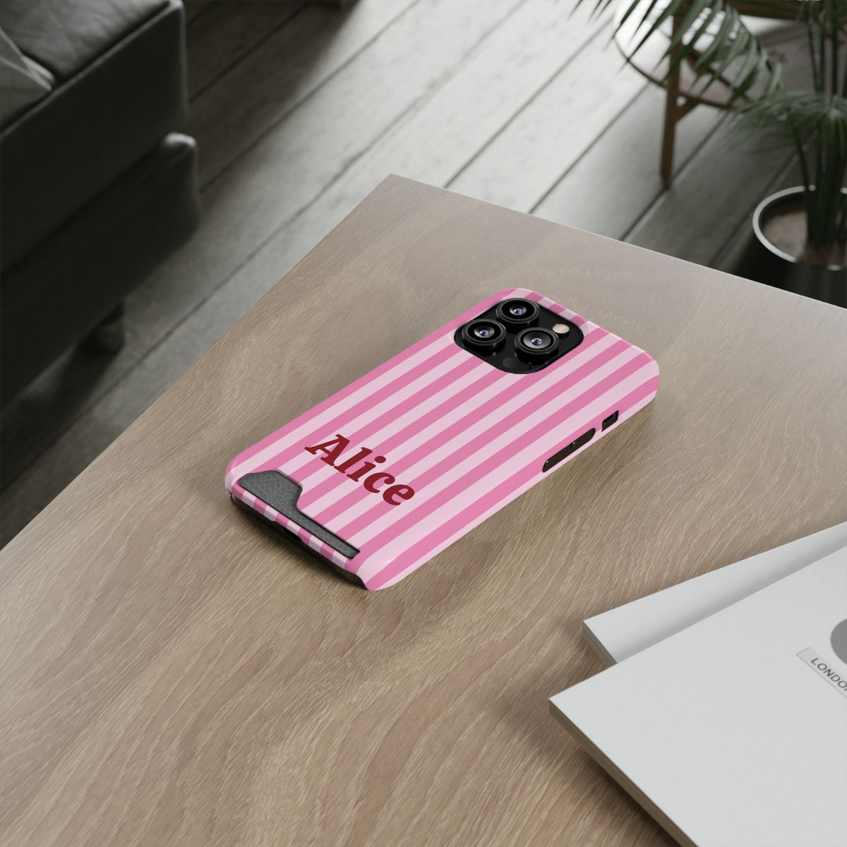 Pink Cabana Stripe card holder phone case on a wooden desk