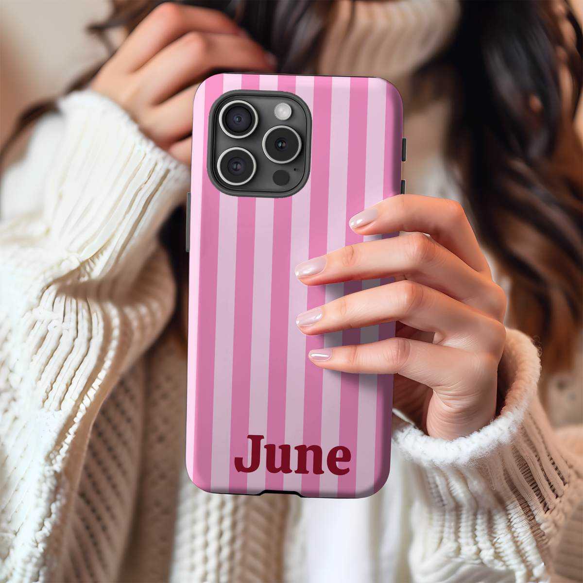 Woman holding a Pink Cabana Stripe phone case personalized with a name
