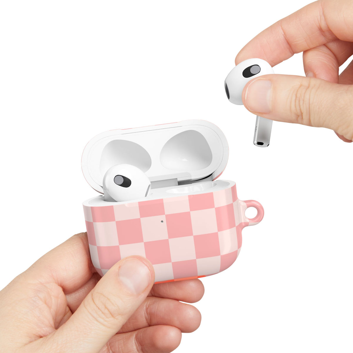 Pink Checkerboard AirPods case held in hand with an earbud